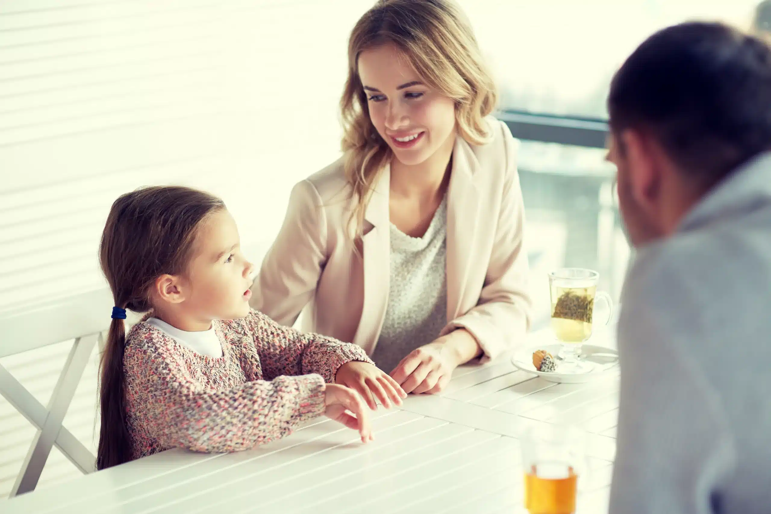 family parenthood communication people concept happy mother father little girl having dinner talking restaurant cafe scaled